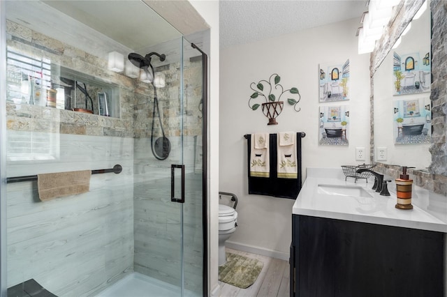 bathroom featuring vanity, toilet, a textured ceiling, an enclosed shower, and wood-type flooring