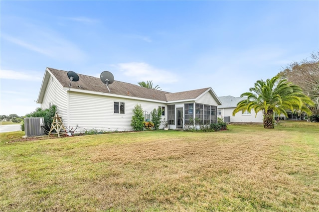 back of property with a yard, cooling unit, and a sunroom