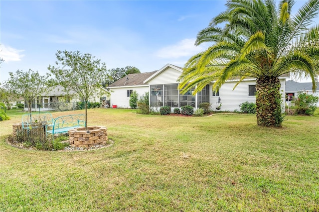 view of yard with a sunroom and an outdoor fire pit