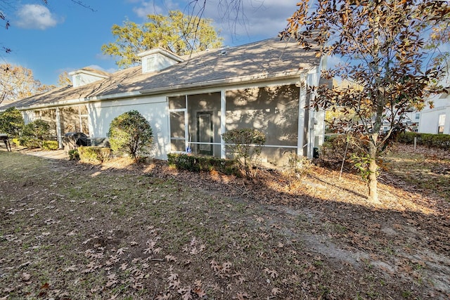 back of property with a sunroom