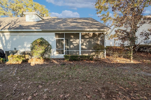 rear view of property with central AC and a sunroom