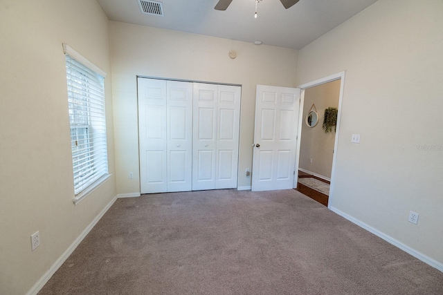 unfurnished bedroom with ceiling fan, a closet, and carpet