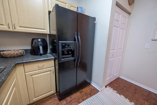 kitchen featuring dark hardwood / wood-style floors, black fridge with ice dispenser, and light brown cabinetry