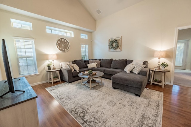 living room with dark hardwood / wood-style flooring and high vaulted ceiling