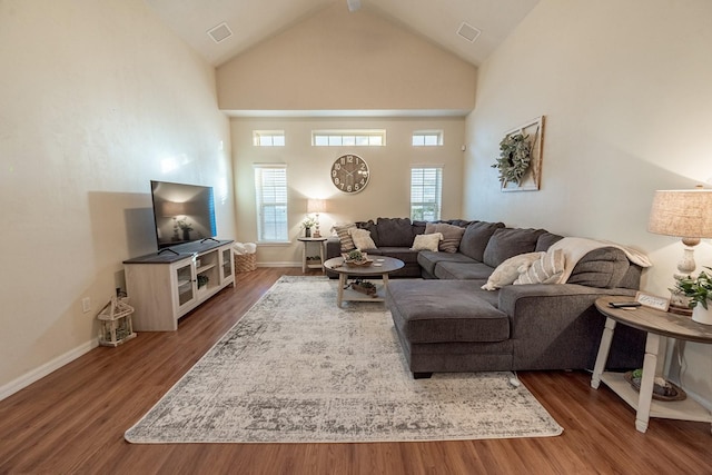 living room featuring high vaulted ceiling and dark wood-type flooring