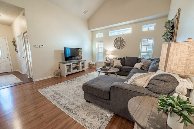 living room with dark hardwood / wood-style flooring and high vaulted ceiling