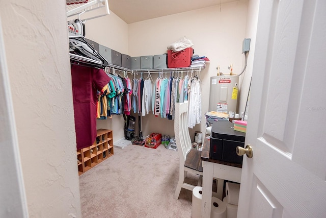 spacious closet with electric water heater and carpet floors