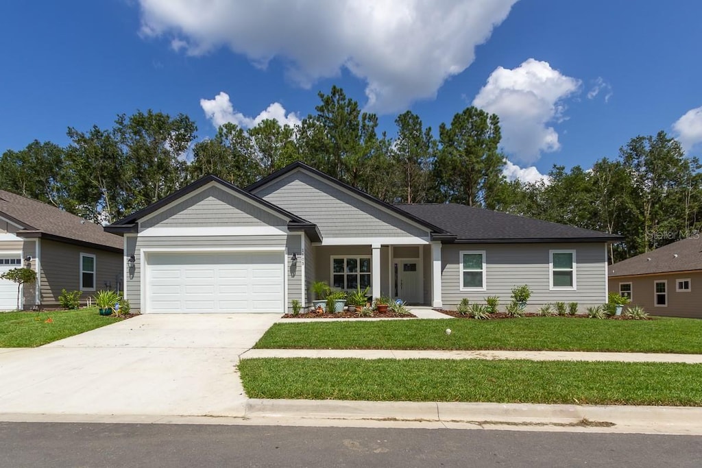 ranch-style house featuring a garage and a front lawn