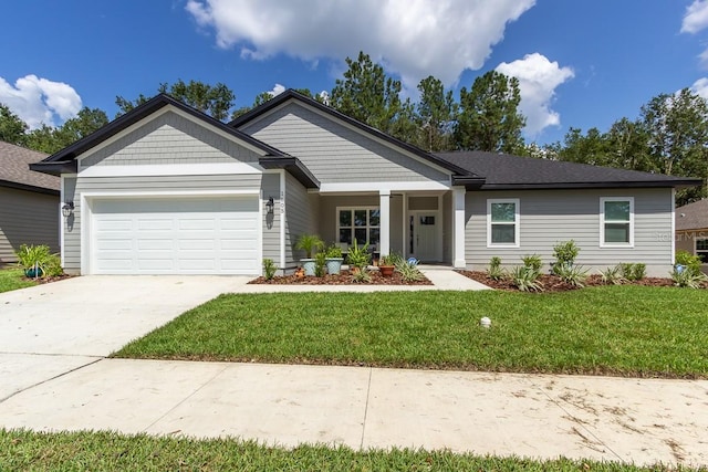 view of front of home with a front yard and a garage