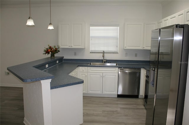 kitchen with white cabinets, sink, decorative light fixtures, kitchen peninsula, and stainless steel appliances