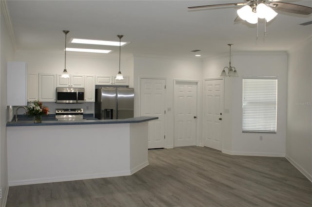 kitchen with pendant lighting, white cabinetry, kitchen peninsula, and appliances with stainless steel finishes