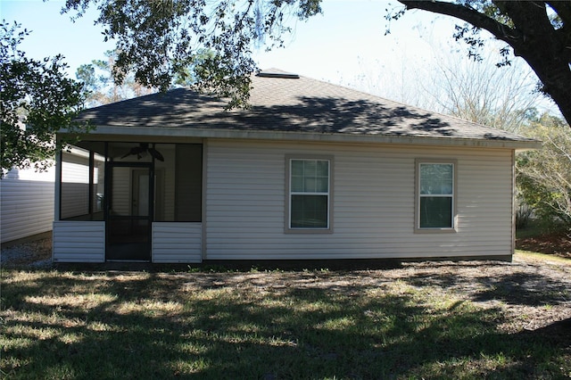 rear view of house featuring a lawn and a sunroom