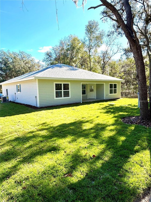 view of front facade featuring central AC unit and a front yard