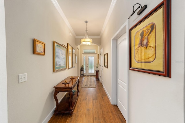 hallway featuring crown molding, hardwood / wood-style floors, and french doors