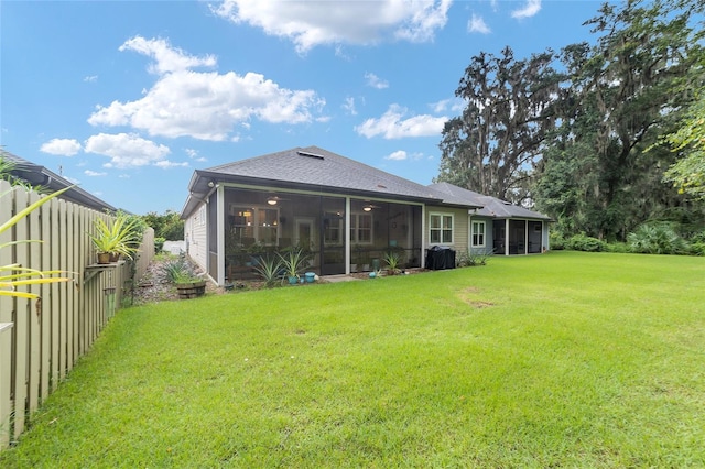 back of property with a lawn and a sunroom