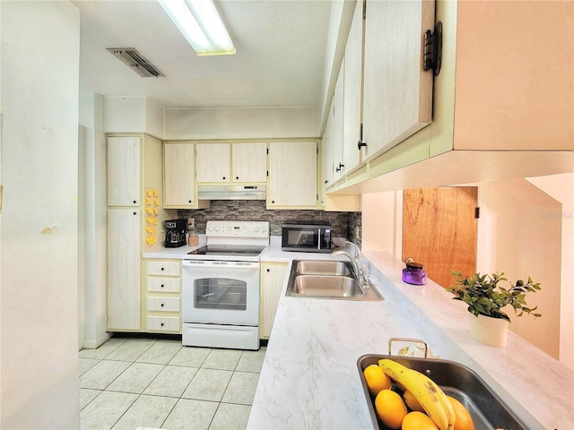 kitchen featuring white electric range, light tile patterned floors, sink, cream cabinets, and tasteful backsplash