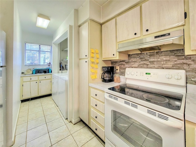 kitchen with white range with electric cooktop, washer and dryer, light tile patterned floors, and decorative backsplash