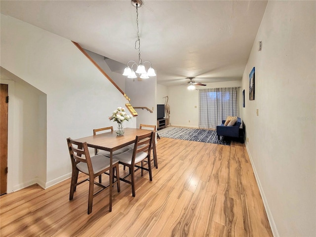 dining area with ceiling fan with notable chandelier and light wood-type flooring