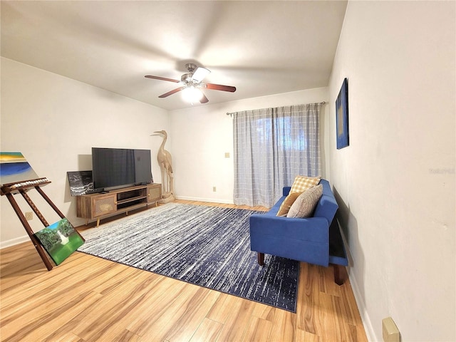 living room featuring hardwood / wood-style floors and ceiling fan