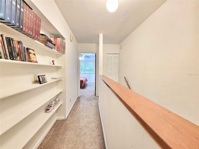 corridor featuring light colored carpet