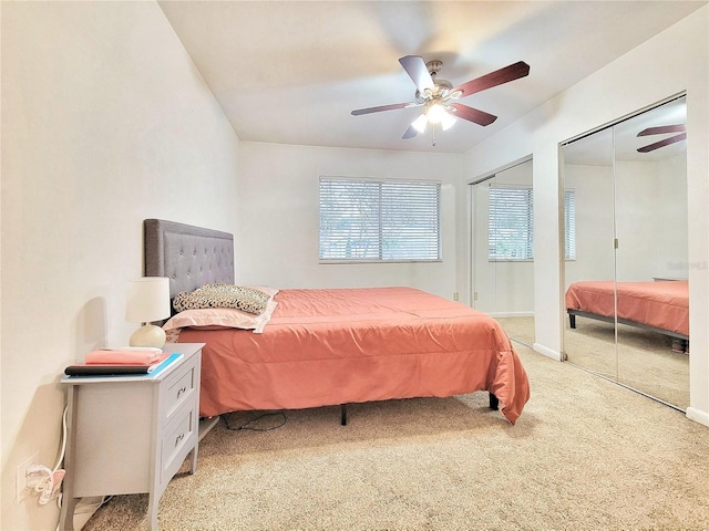 carpeted bedroom with two closets and ceiling fan