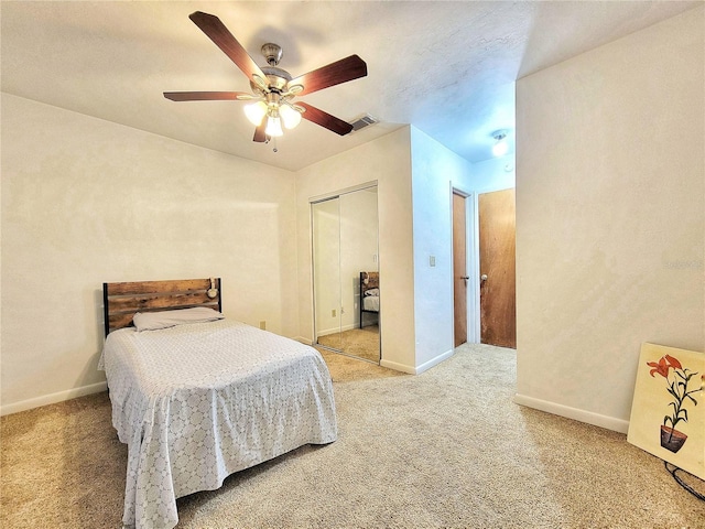 carpeted bedroom with ceiling fan and a closet