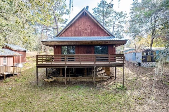 back of house featuring a deck and a storage unit