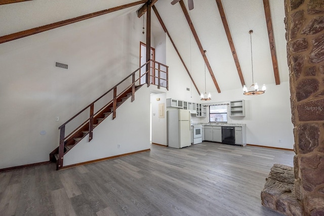 unfurnished living room featuring sink, hardwood / wood-style flooring, an inviting chandelier, high vaulted ceiling, and beamed ceiling