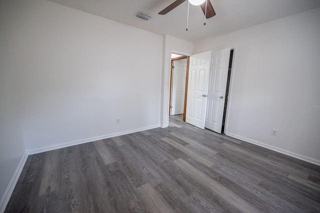 unfurnished bedroom with a textured ceiling, ceiling fan, and dark wood-type flooring