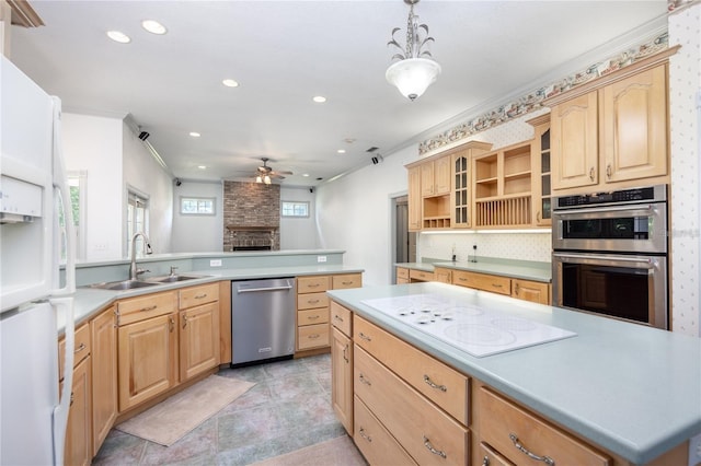 kitchen featuring ceiling fan, sink, light brown cabinets, hanging light fixtures, and stainless steel appliances