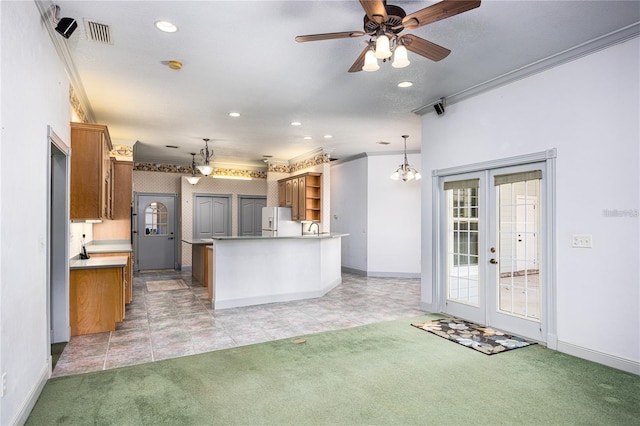 kitchen featuring french doors, ceiling fan with notable chandelier, hanging light fixtures, white fridge with ice dispenser, and light colored carpet