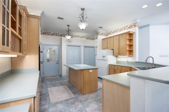 kitchen with a center island, white refrigerator with ice dispenser, crown molding, sink, and decorative light fixtures