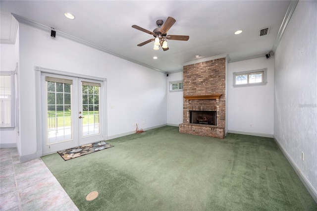 unfurnished living room featuring ceiling fan, a fireplace, french doors, and ornamental molding