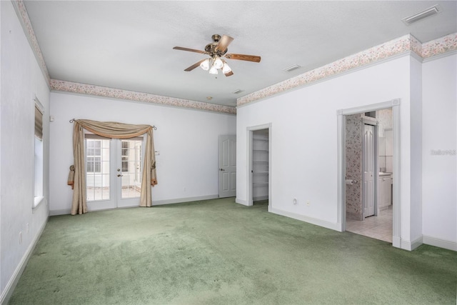 carpeted empty room with ceiling fan and french doors