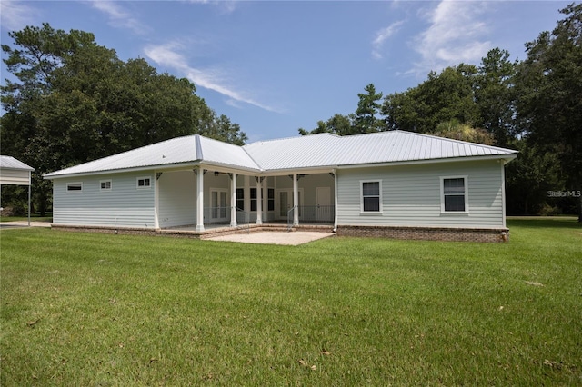 back of property featuring a patio area and a lawn