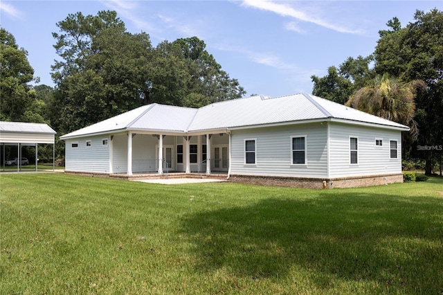 back of house with a yard, covered porch, and a carport