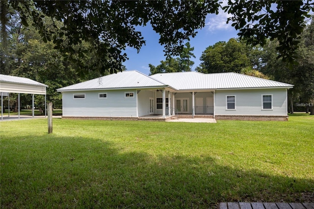 rear view of house featuring a yard and a carport