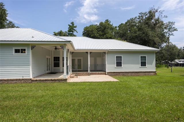 rear view of property featuring a lawn, ceiling fan, a patio area, and french doors