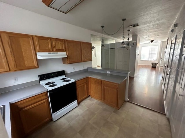 kitchen with decorative light fixtures, electric range oven, and kitchen peninsula