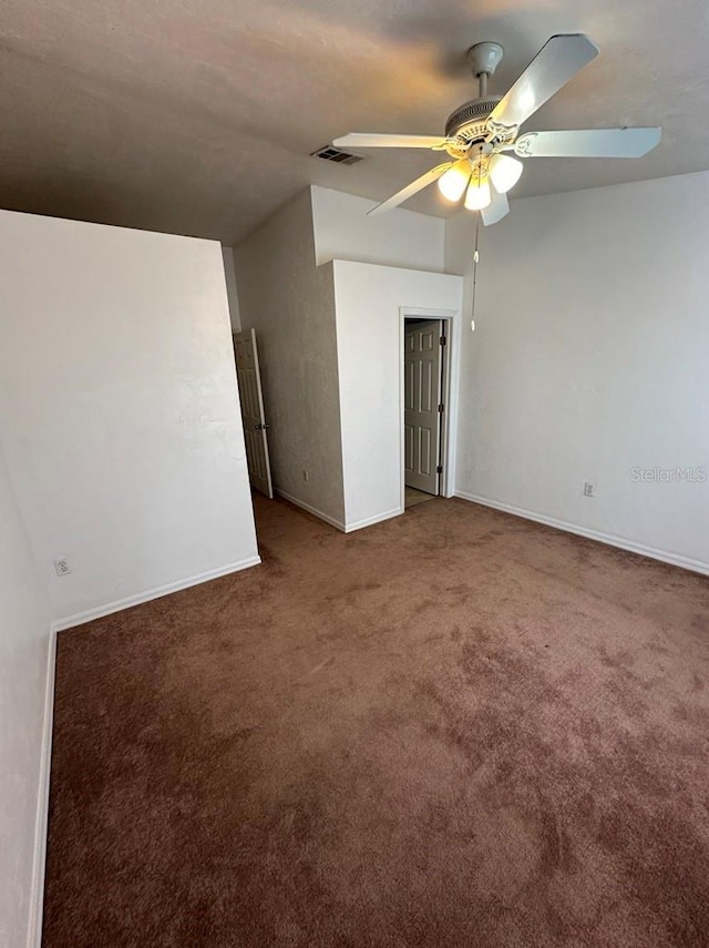 empty room featuring carpet floors, vaulted ceiling, and ceiling fan