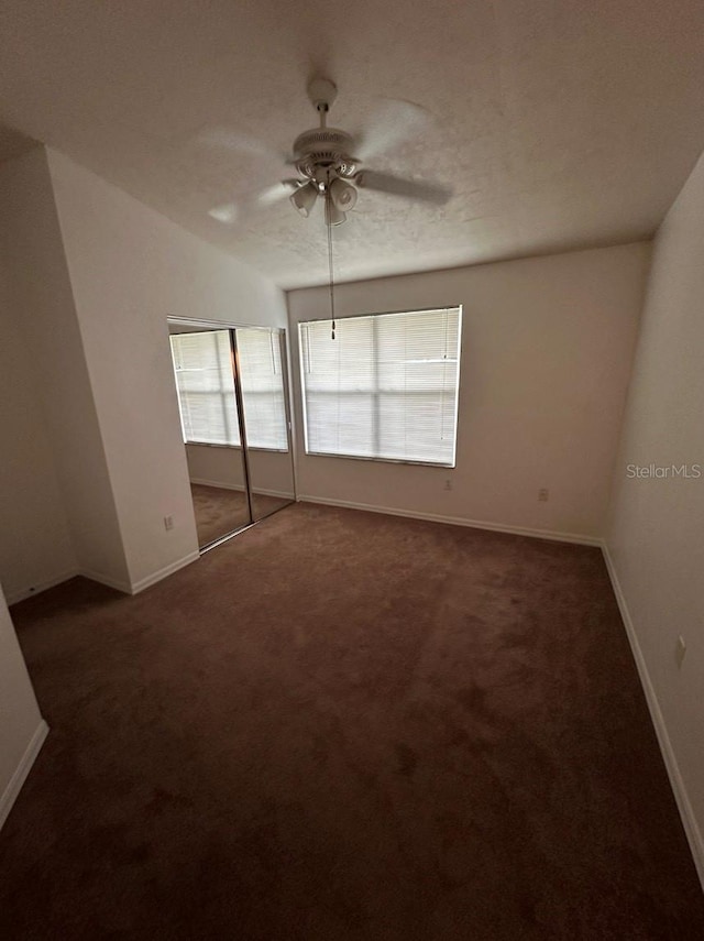 carpeted spare room featuring a textured ceiling, ceiling fan, and lofted ceiling