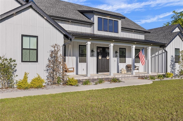 modern farmhouse featuring a porch and a front yard