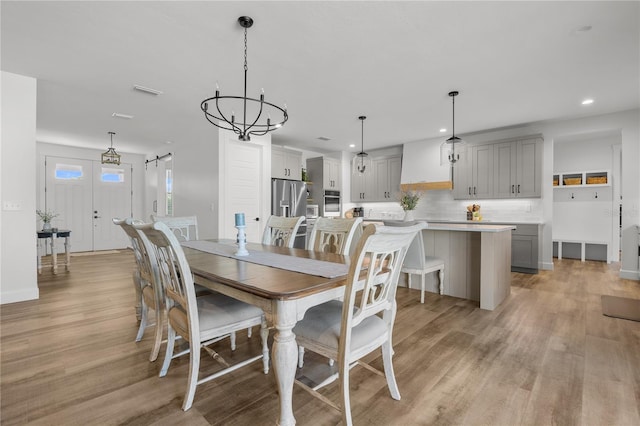 dining area with a notable chandelier and light wood-type flooring