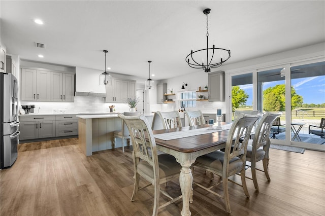 dining area featuring a wealth of natural light, hardwood / wood-style flooring, and a notable chandelier