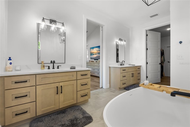 bathroom featuring a bathing tub, tile patterned flooring, and vanity