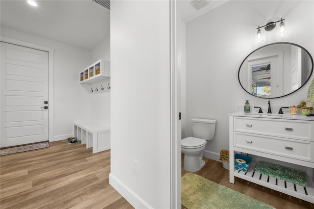 bathroom with hardwood / wood-style floors, vanity, and toilet