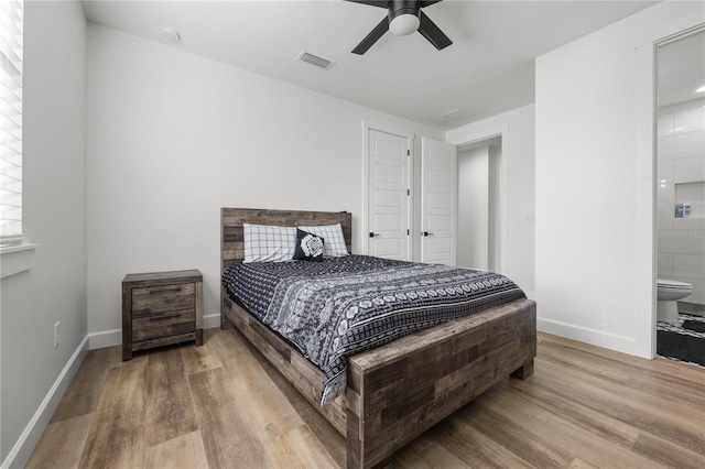 bedroom featuring ensuite bath, ceiling fan, and wood-type flooring