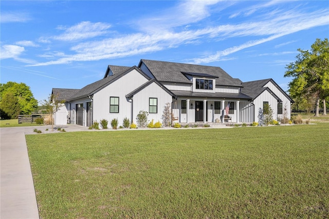 modern farmhouse style home featuring covered porch, a garage, and a front yard