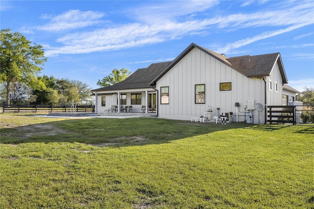 rear view of property featuring a lawn and a patio