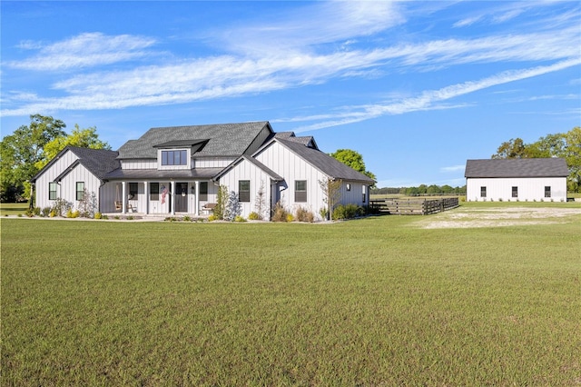 modern farmhouse style home with covered porch and a front yard